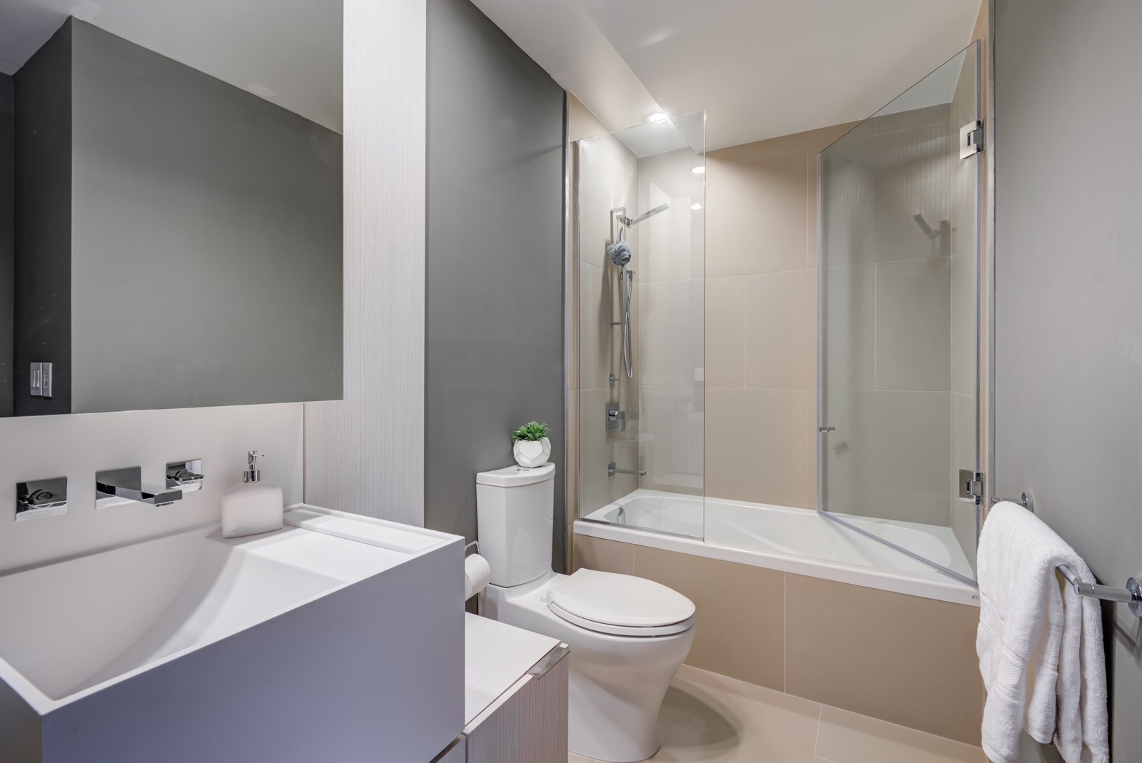 Master bath of 1 Bloor St E Unit 4305 with tub, shower, white sink bowl, and detachable showerhead.