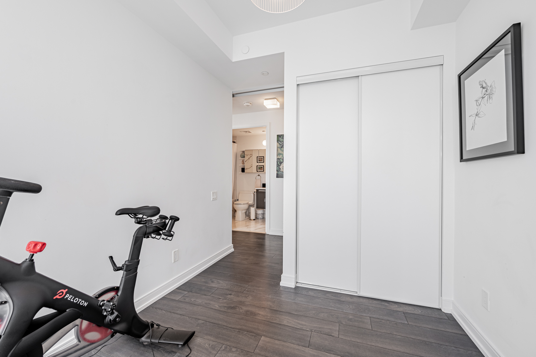 Empty condo bedroom with laminate floors and closet.