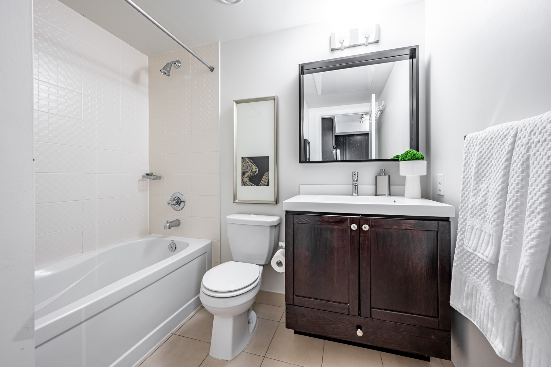 White condo bathroom with brown accents.