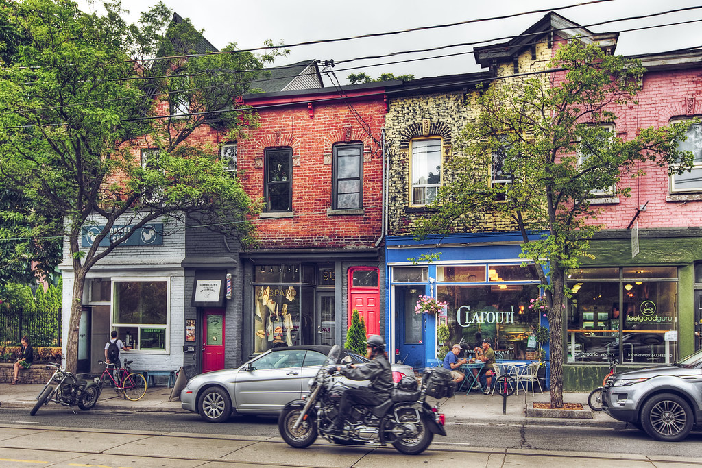 Across-the-street view of cafes and stores in Toronto's Trinity Bellwoods neighbourhood.