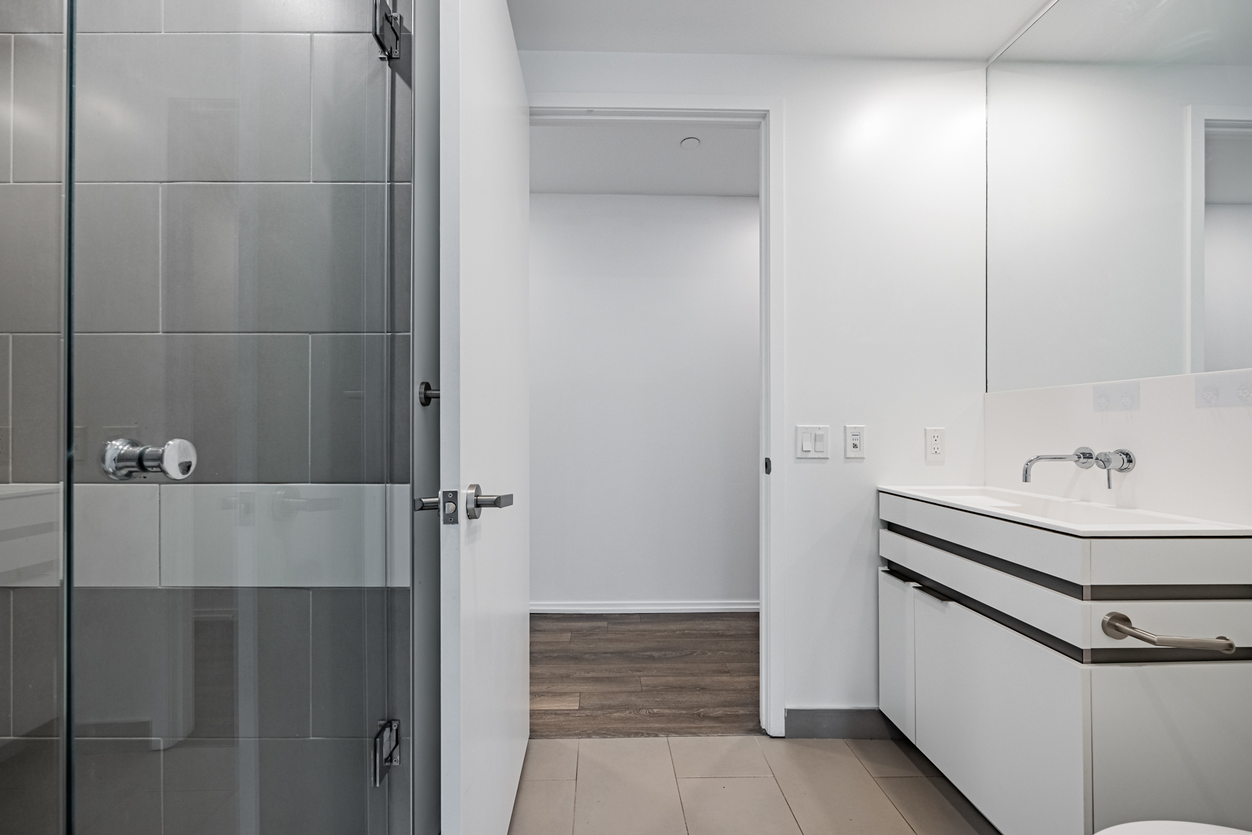 Condo bathroom with standing glass shower.