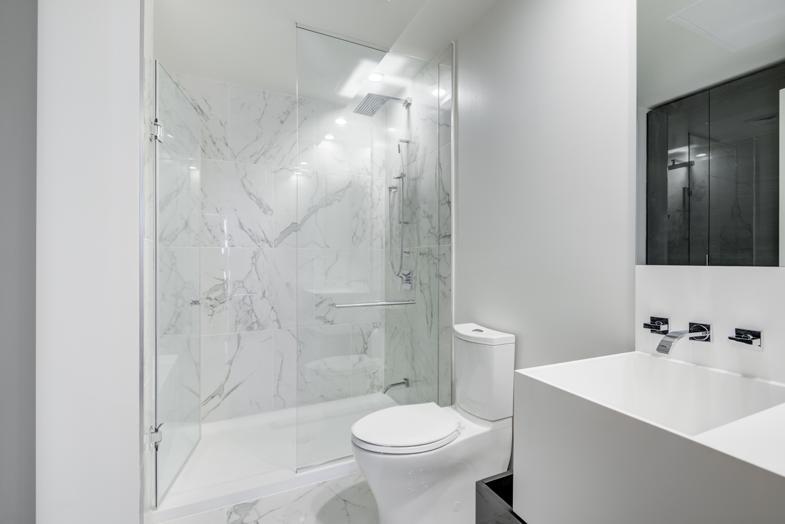 Highlights include a large sink, wall-mounted faucet, tall mirror, and frameless walk-in shower.