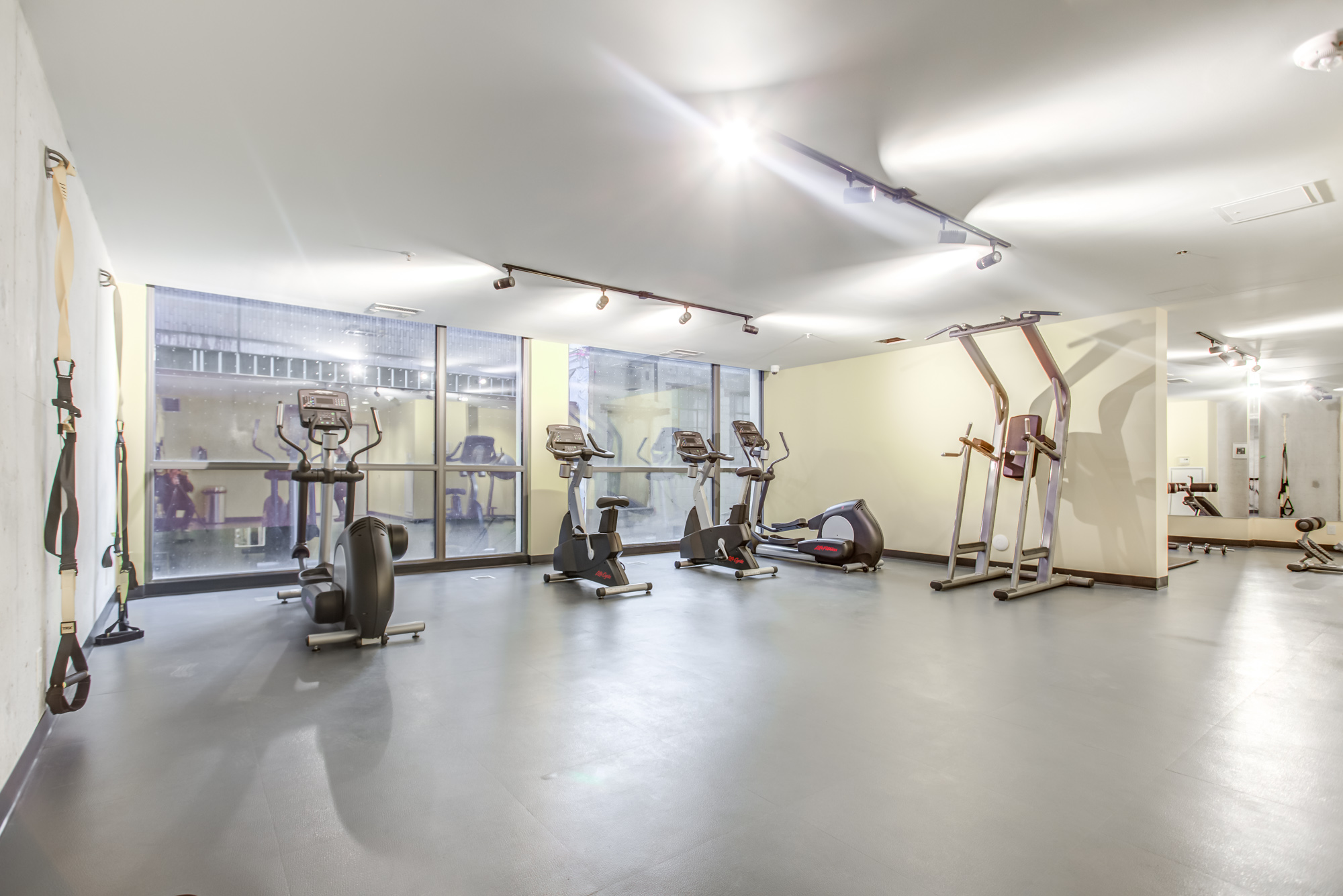 Gym with exercise bike and weights at Brant Park Lofts in Queen West, Toronto.