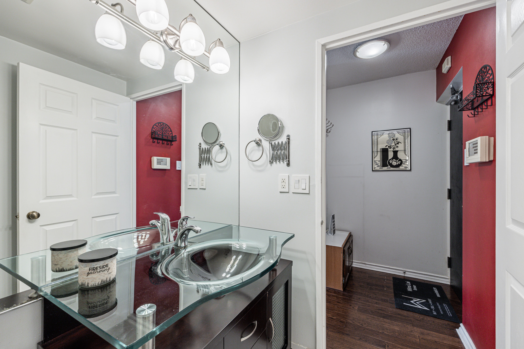 Condo bathroom with glass sink bowl and counter and under-sink cabinet.