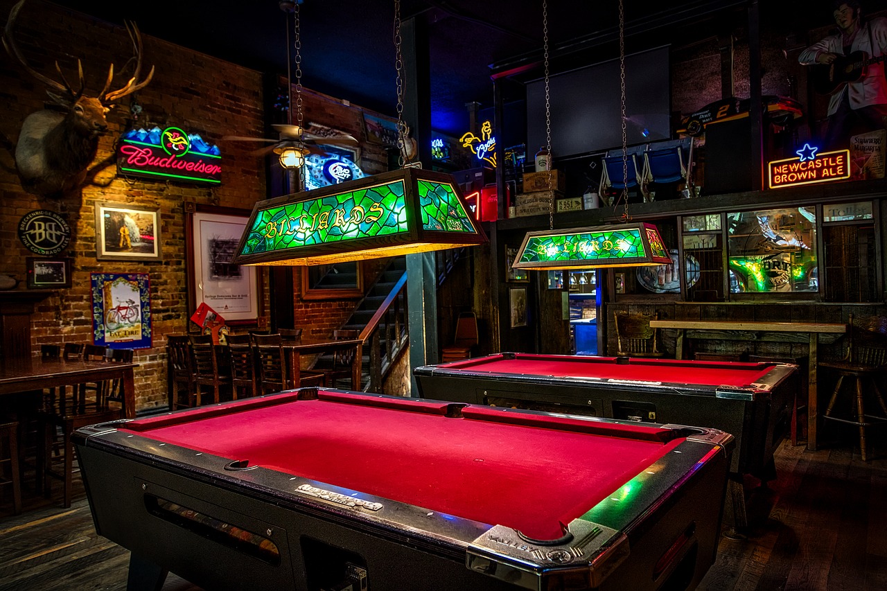 British-style pub with neon beer signs, deer head and billiards tables with red-felt lining.