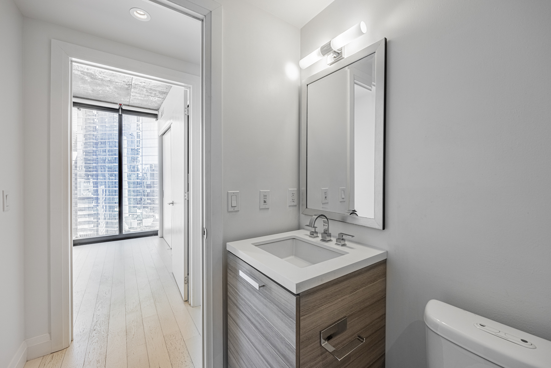 Condo bathroom with view of bedroom.