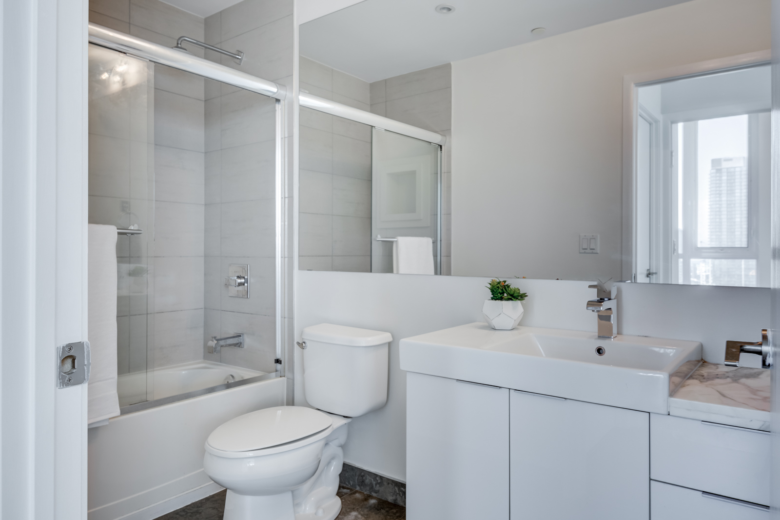 Second bathroom with tub and porcelain tiles at Victory Lofts Penthouse Suite in 478 King St W Toronto.