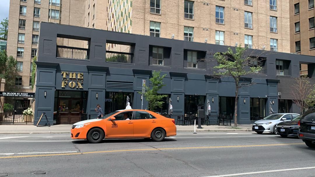 Black and gold exterior of The Fortunate Fox bar on Bloor West in The Annex neighbourhood.