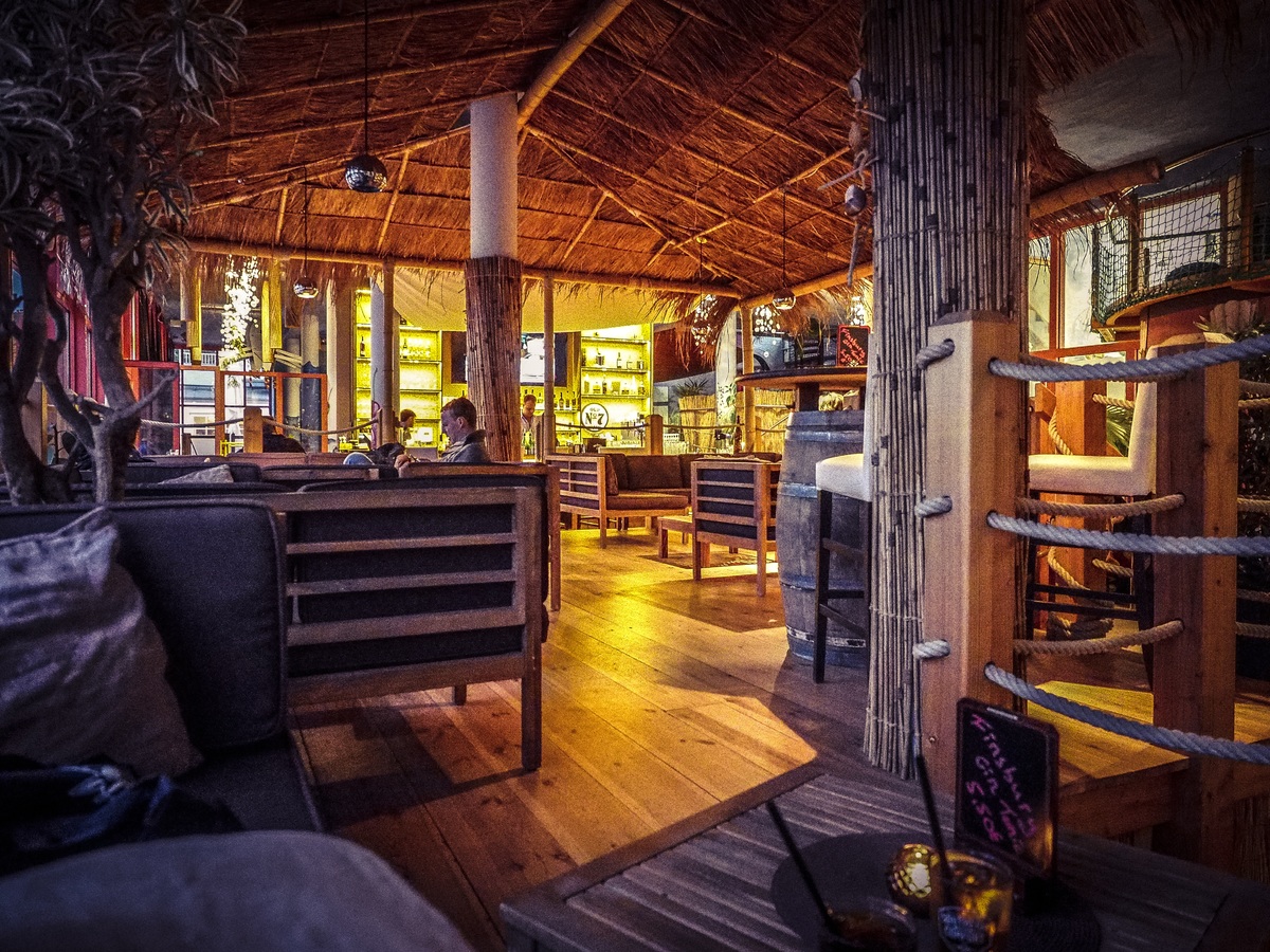 Cottage interior with wooden seats, tables and chairs.