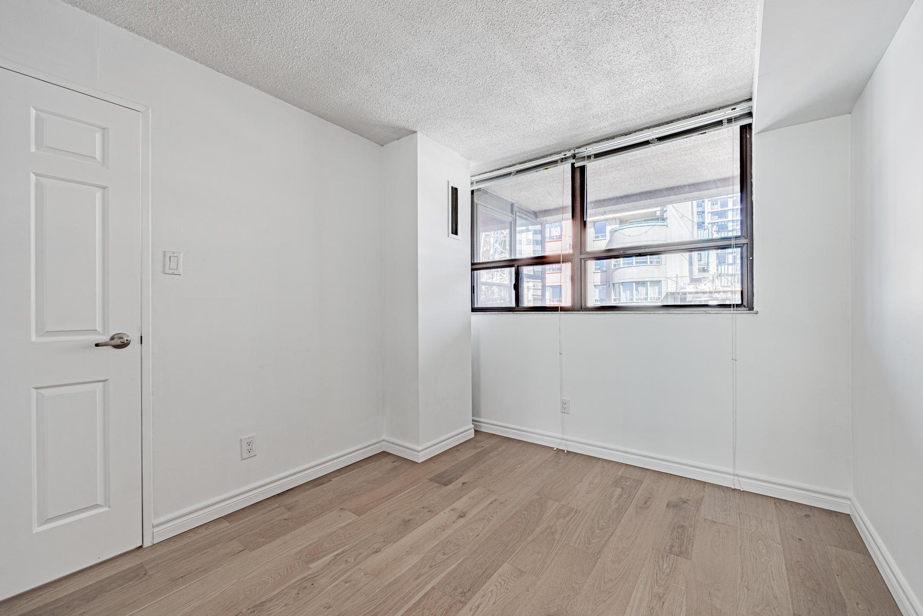 Condo bedroom with large windows.