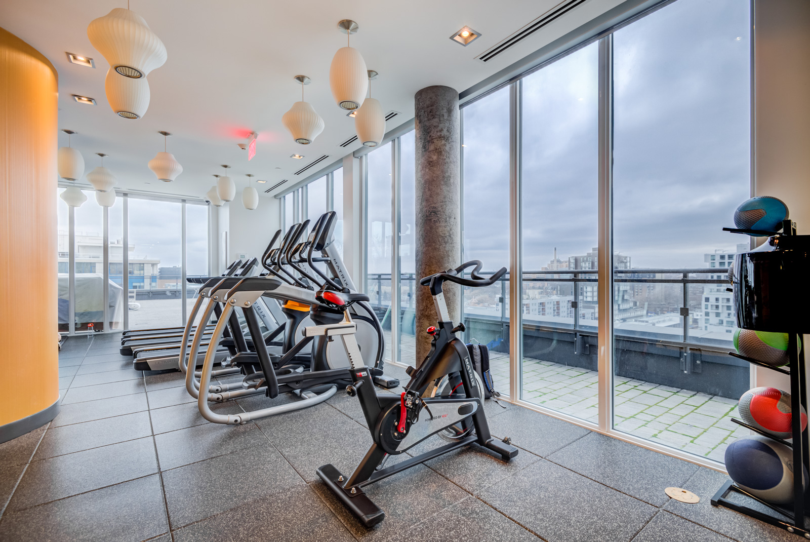 Several stationary bikes facing windows in Fabrik Condos PH 101.