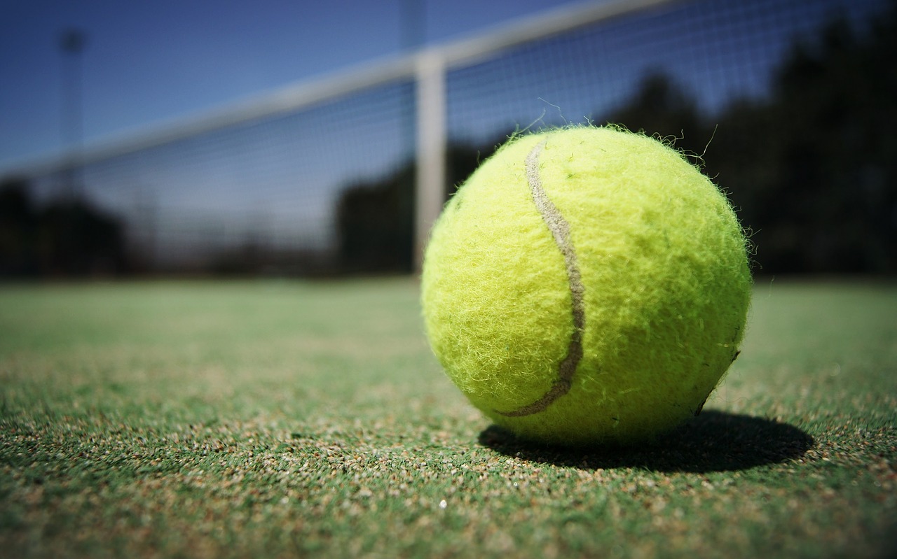 Close up of green tennis ball lying on ground. 