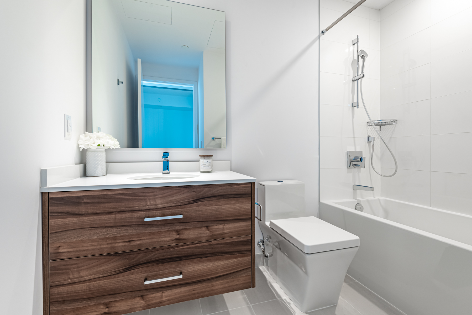 488 University Ave Unit 3102 4-piece bath with gray tiles and dark brown drawers.