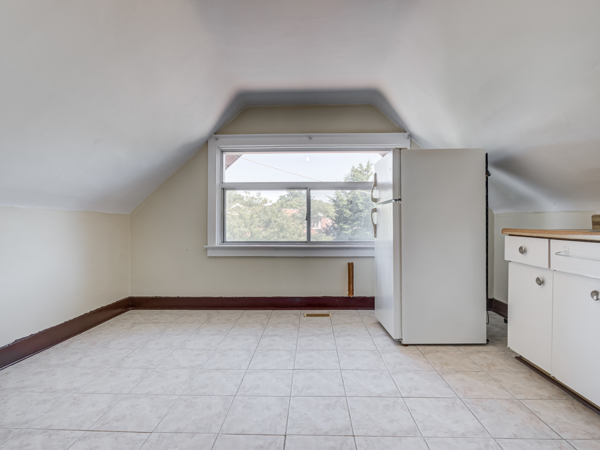 Loft kitchen with large windows and fridge.