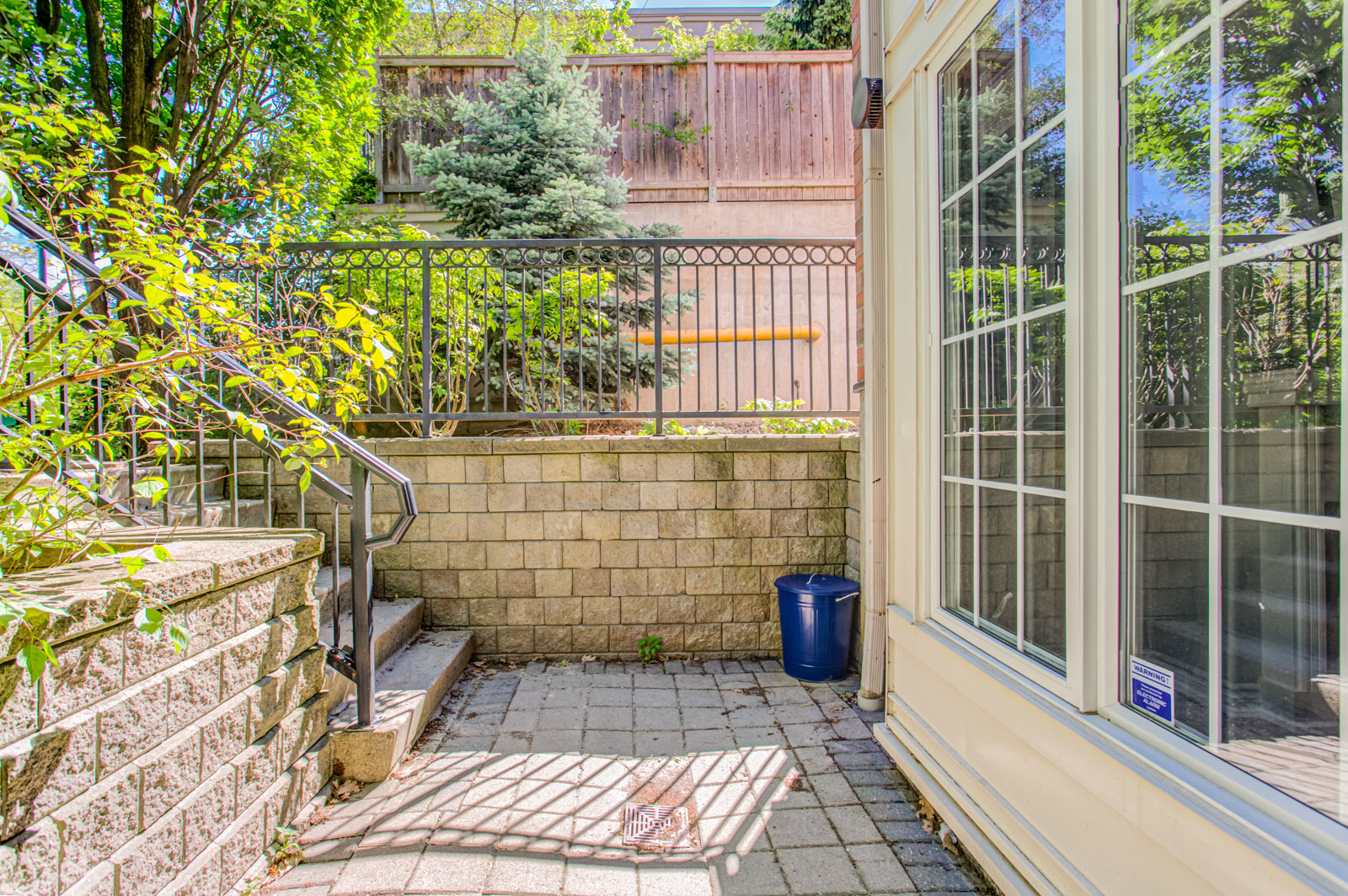 Private front terrace with stone floors and shrubbery.