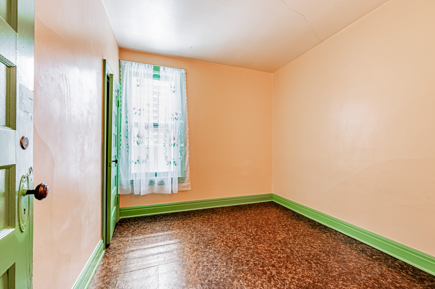 Small bedroom with linoleum floors, closet and window.