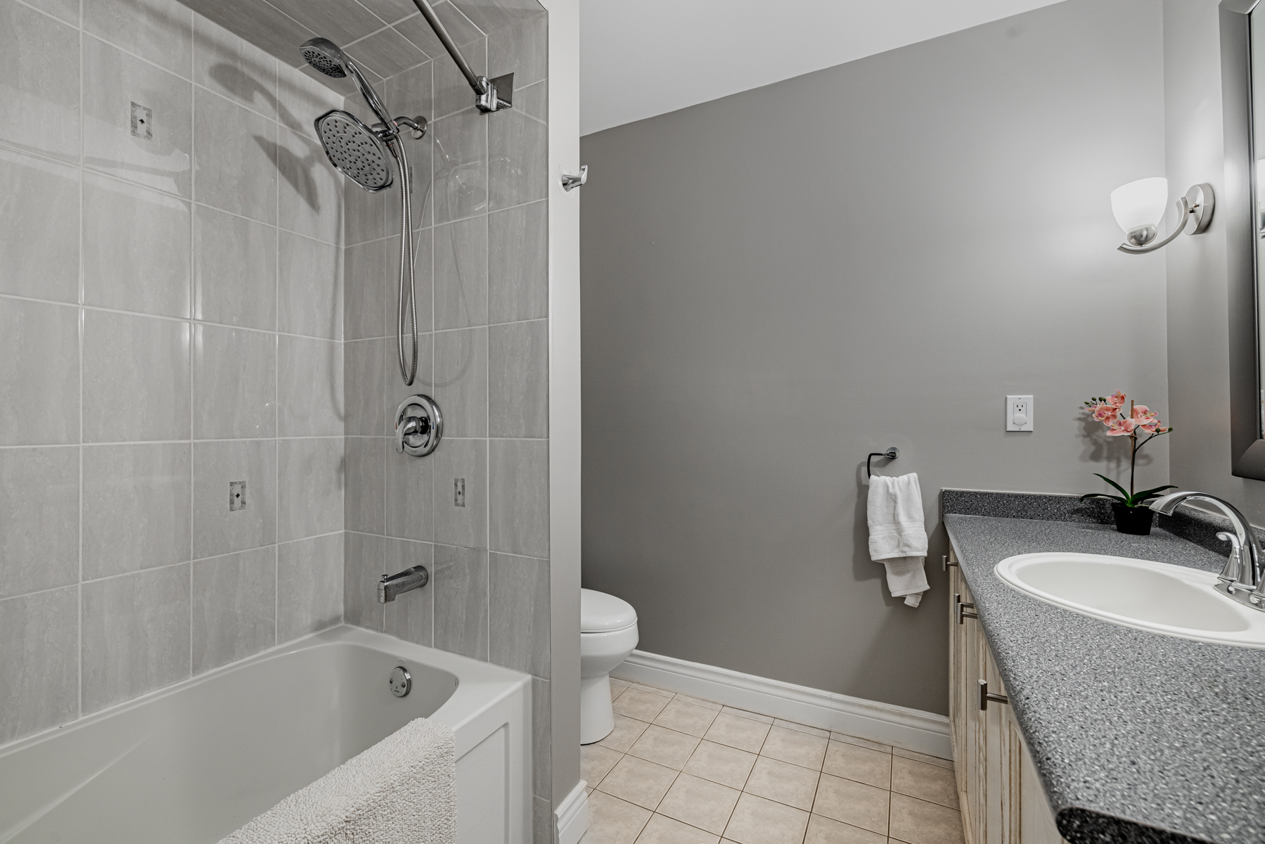 77 Schouten Cres 3-piece bath with gray walls, tiles and counters.