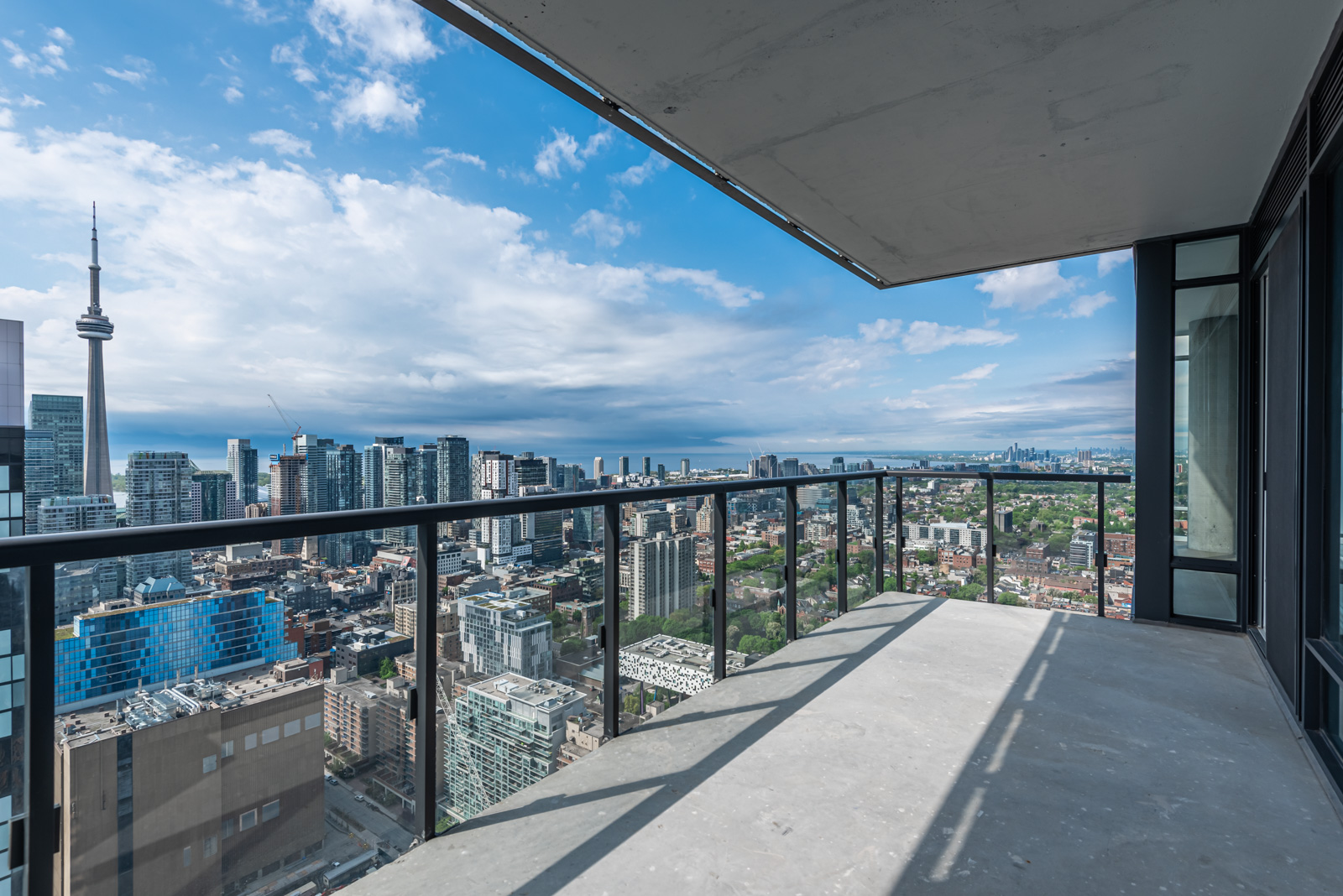 Balcony with clear glass panels showing CN Tower and Toronto.