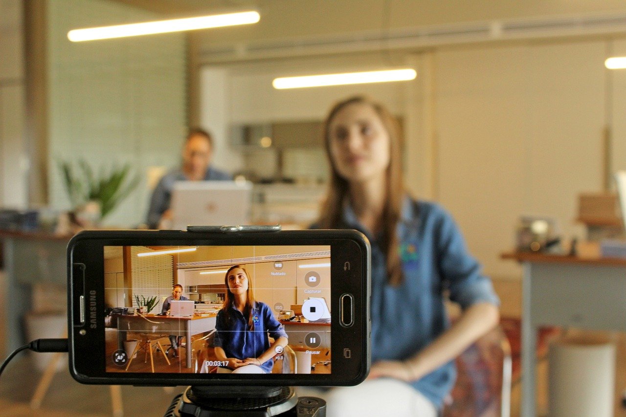 Cellphone camera filming young woman.