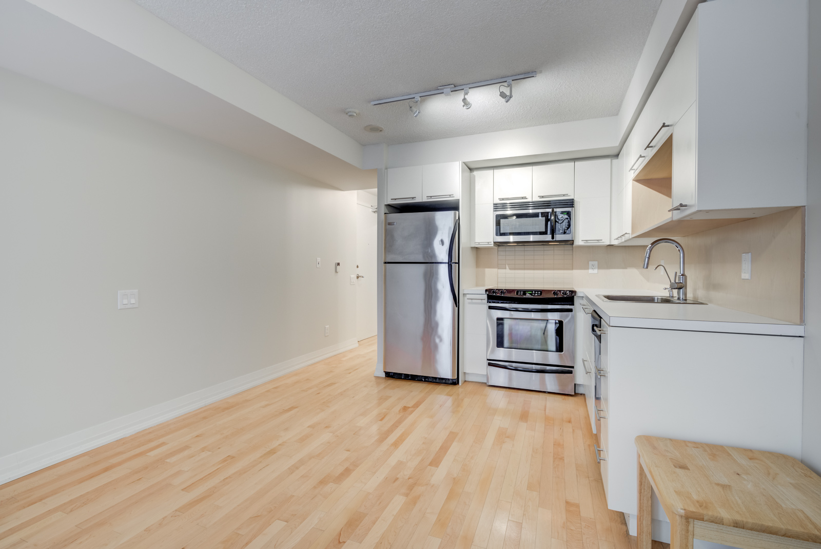 Wide angle shot of 25 Carlton St Unit 401's kitchen and living room.