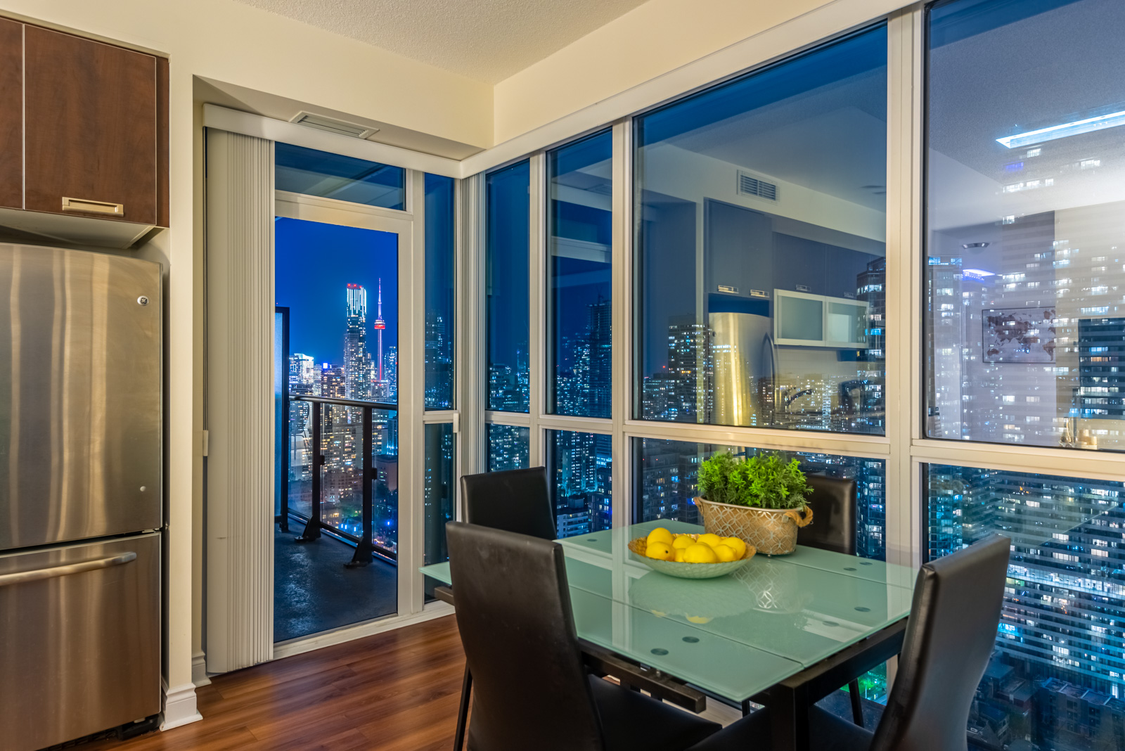 Dining room view of Toronto at night from 28 Ted Rogers Way Unit 3609.