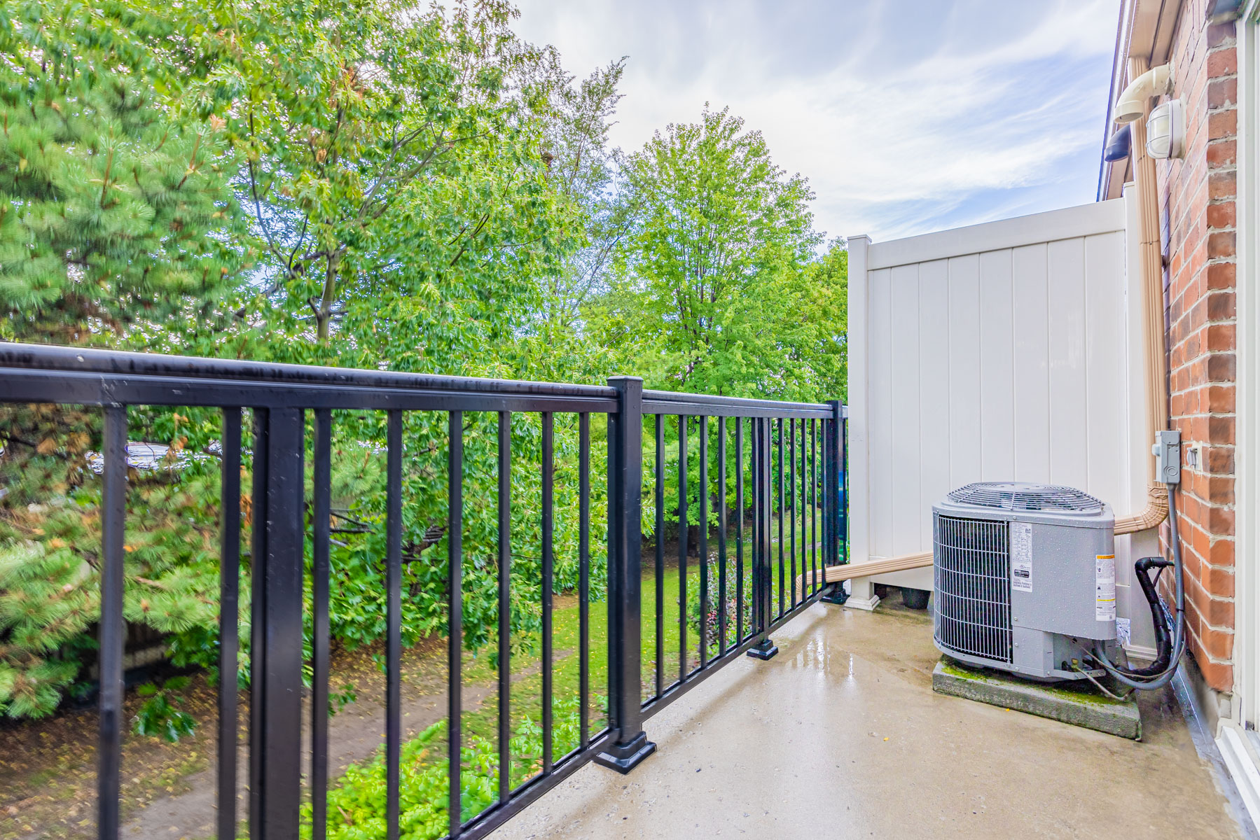 Balcony with wood divider and black rails.