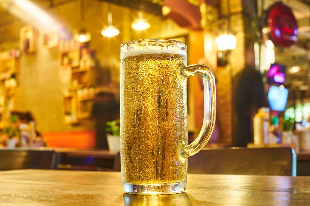 Close up of glass of gold beer on counter.