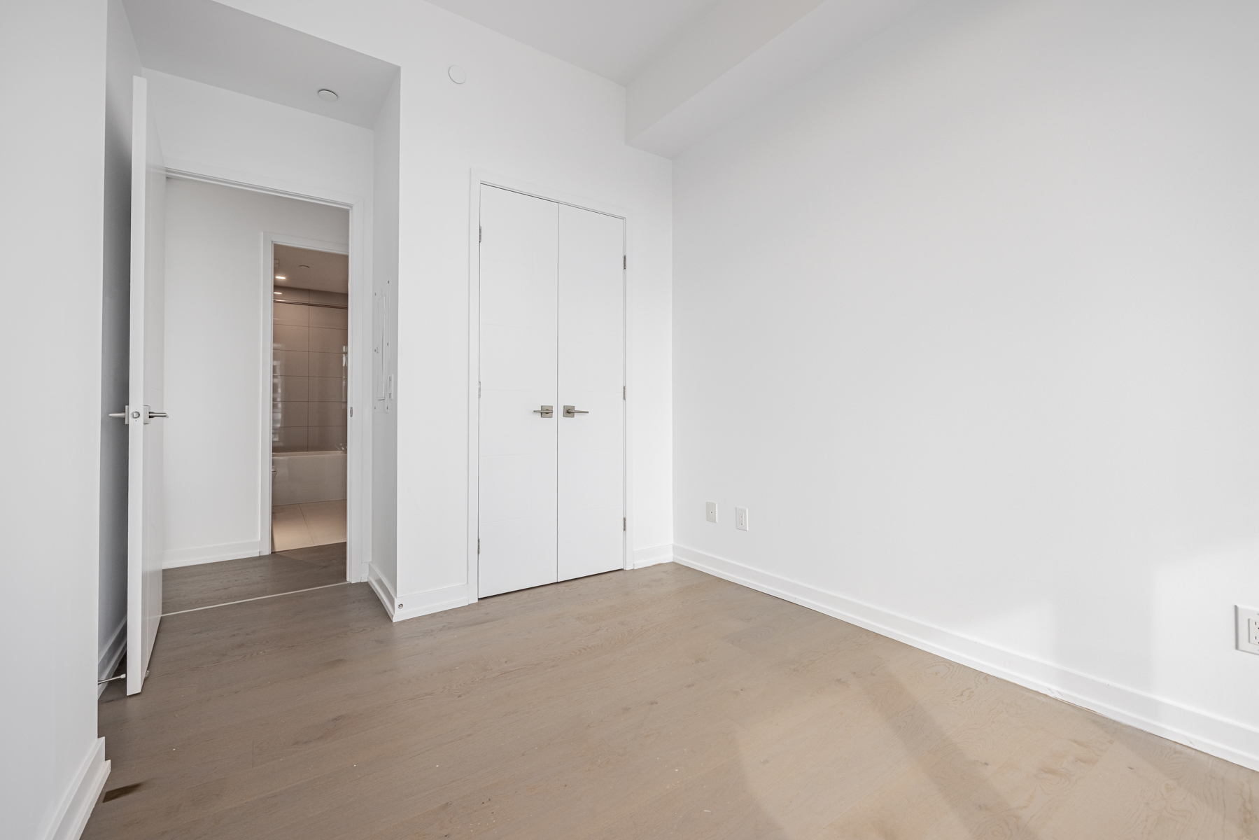 Condo bedroom with double-door closet.