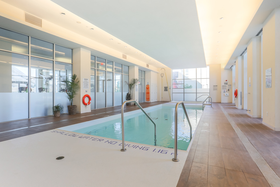 Indoor swimming pool with green water at Dream Tower at Emerald City Condos, Toronto.