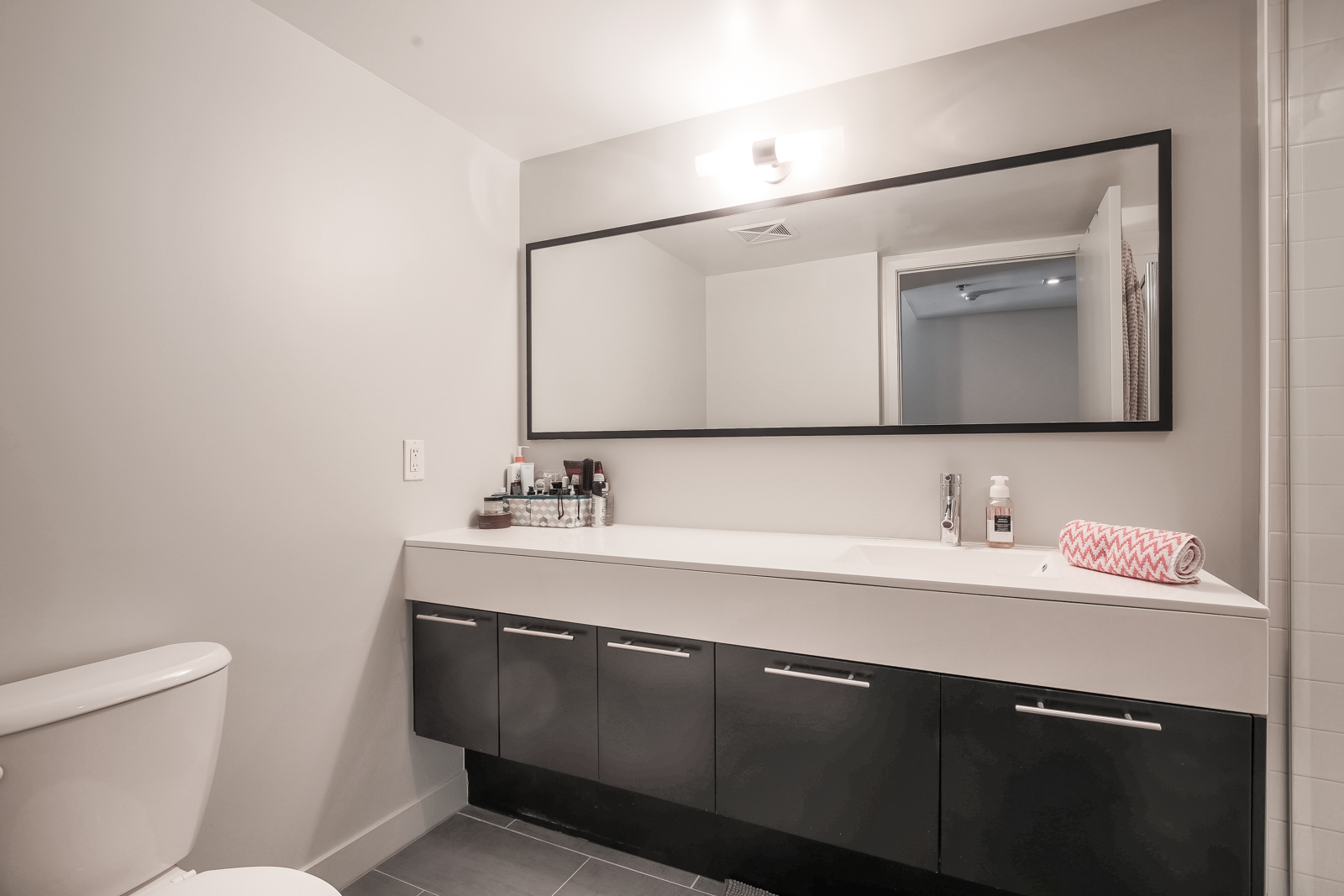 Photo showing 1 of the condo's 2 large bathrooms. This one has a wide, gorgeous mirror and clean lines