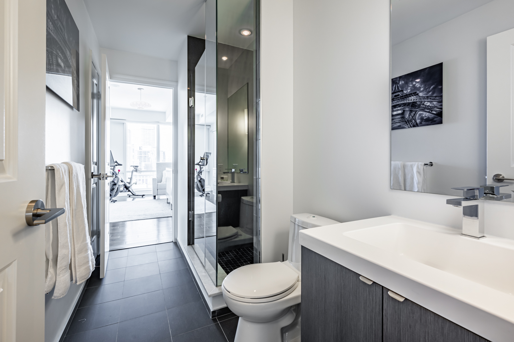 3-piece ensuite bath with dark tiles and glass shower.