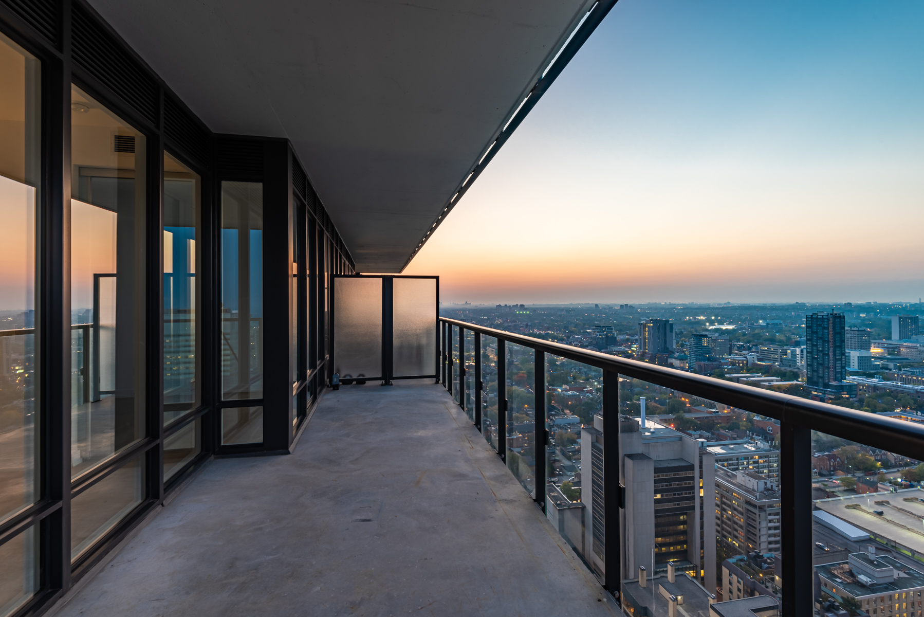 Large balcony with clear glass panels.