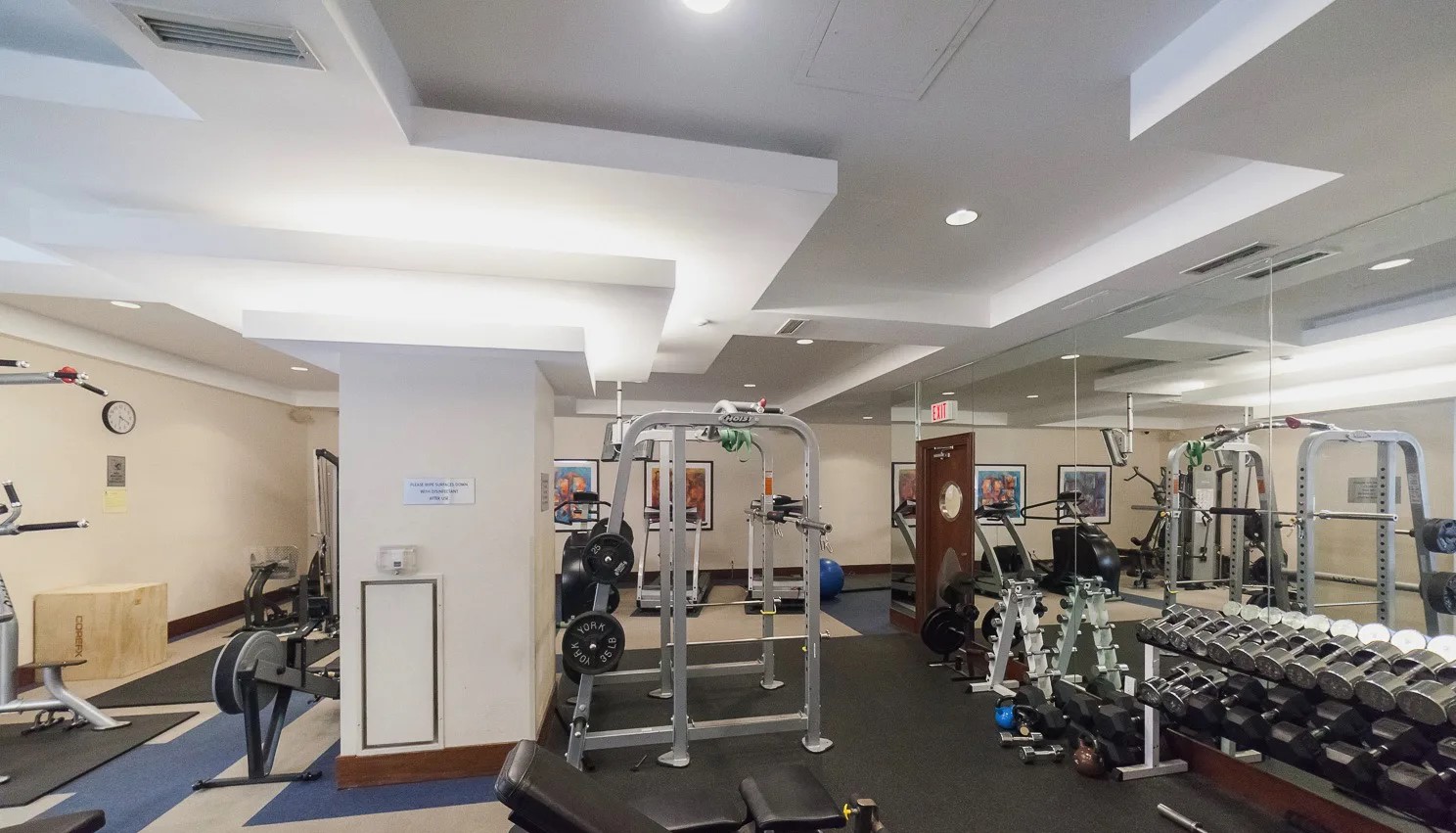 Qwest Condos gym with weights, dumbbells and other exercise equipment.