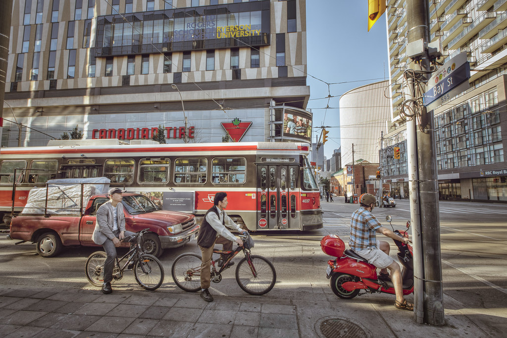 Ryerson University, red Toronto streetcar and cyclists on Bay St.