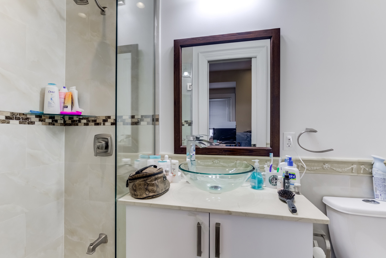 3-piece ensuite bath with vessel sink, crystal bowl, glass shower enclosure and rectangular mirror.