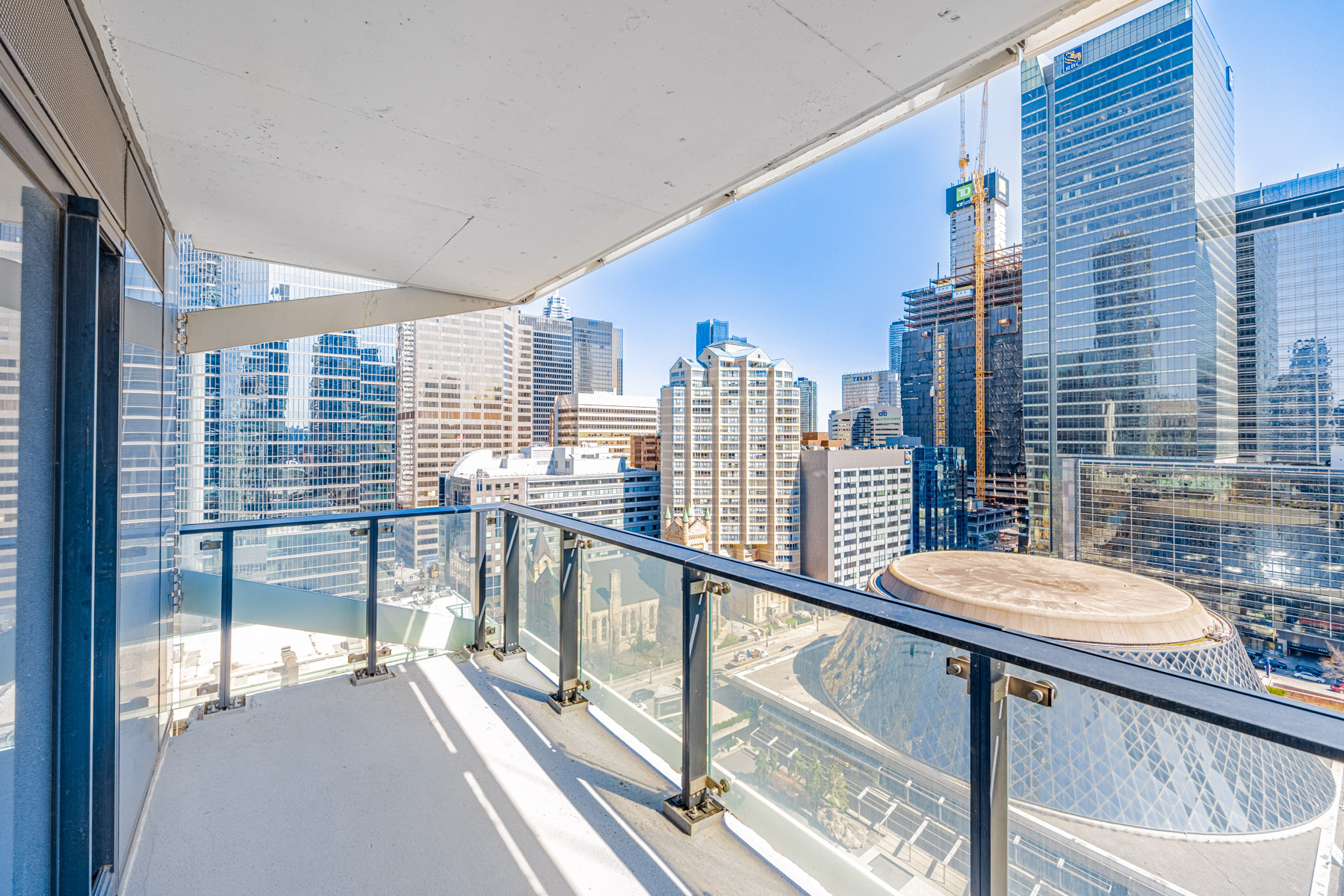 Condo balcony with transparent glass panels.