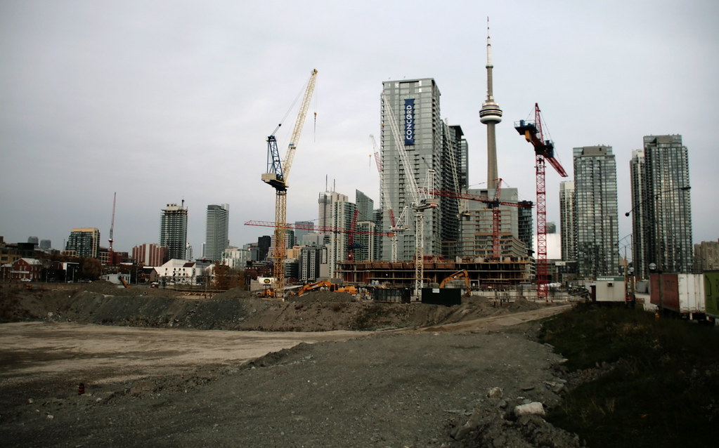 Construction cranes in the Fashion District with CN Tower in background.