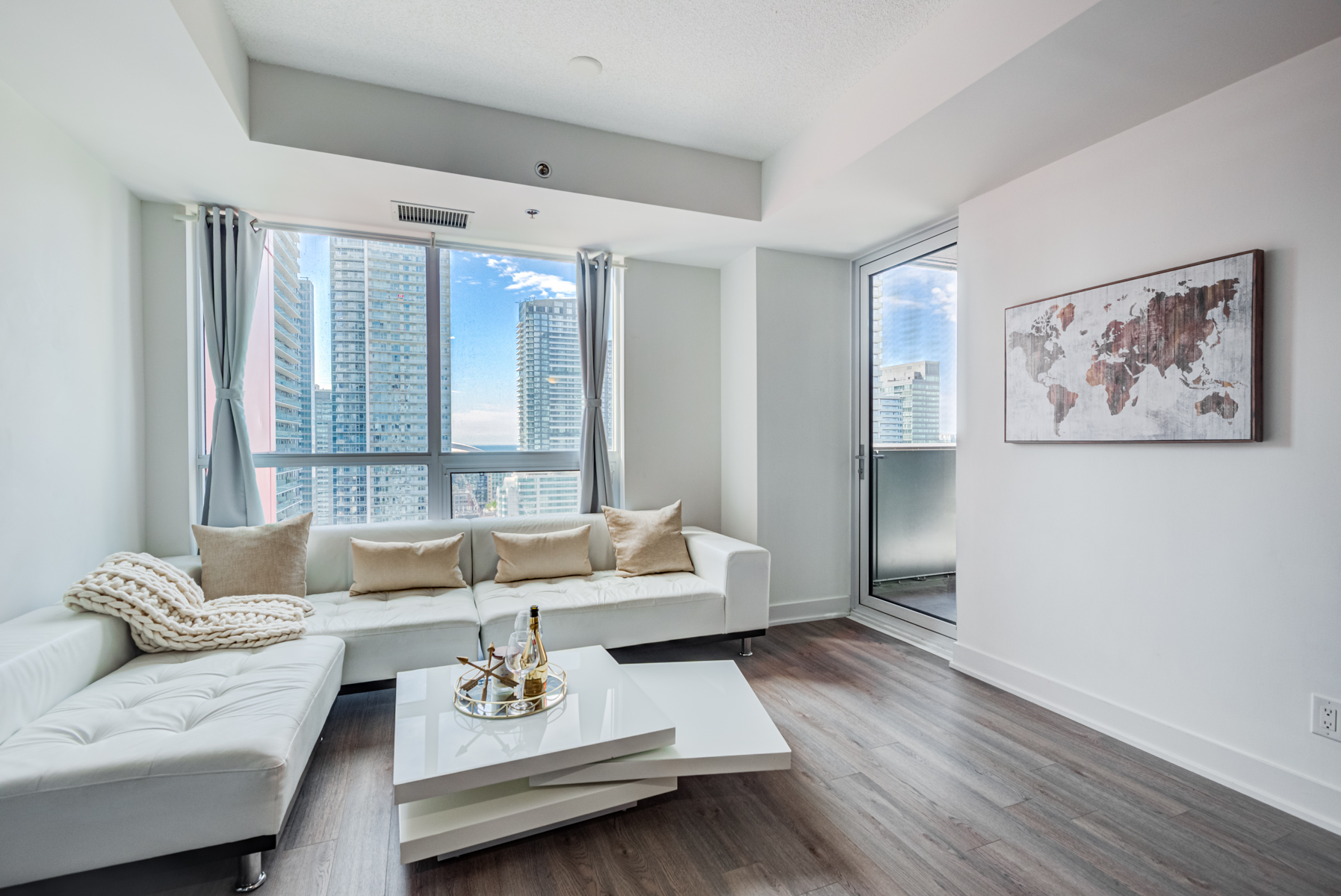 Condo living room with gray walls and dark laminate floors.