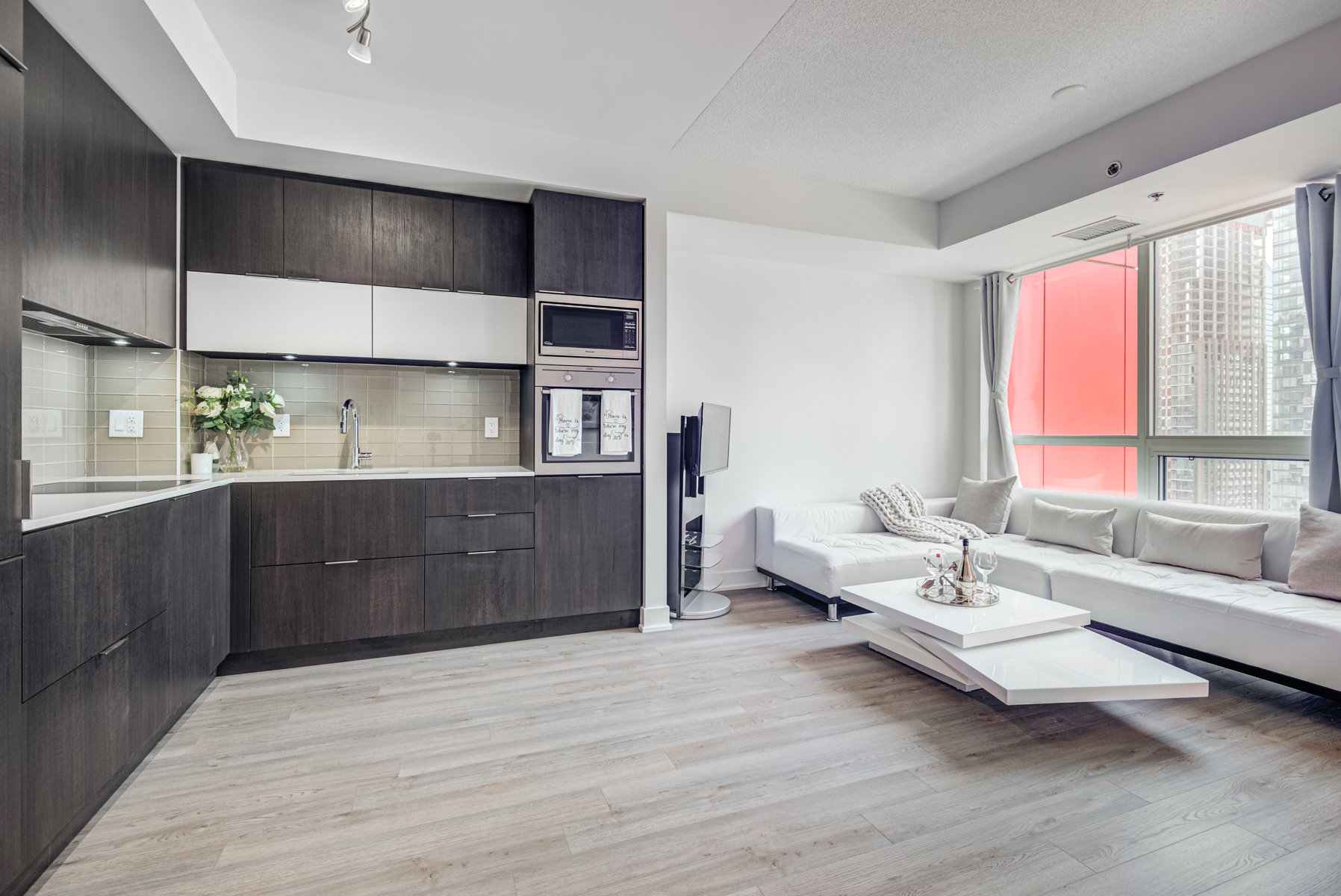 Sleek and elegant condo kitchen with dark cabinets.