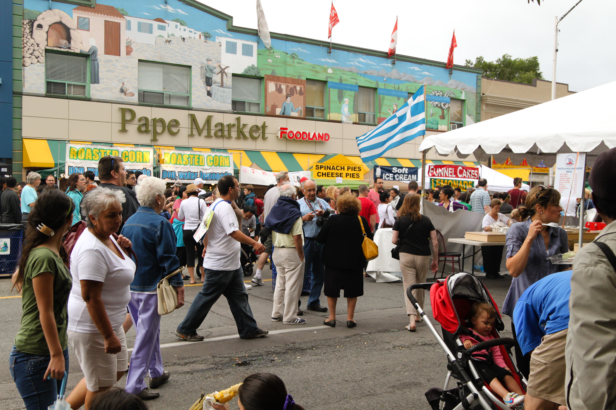 Flags, stores and people celebrating Taste of Danforth Festival in Greektown Toronto.