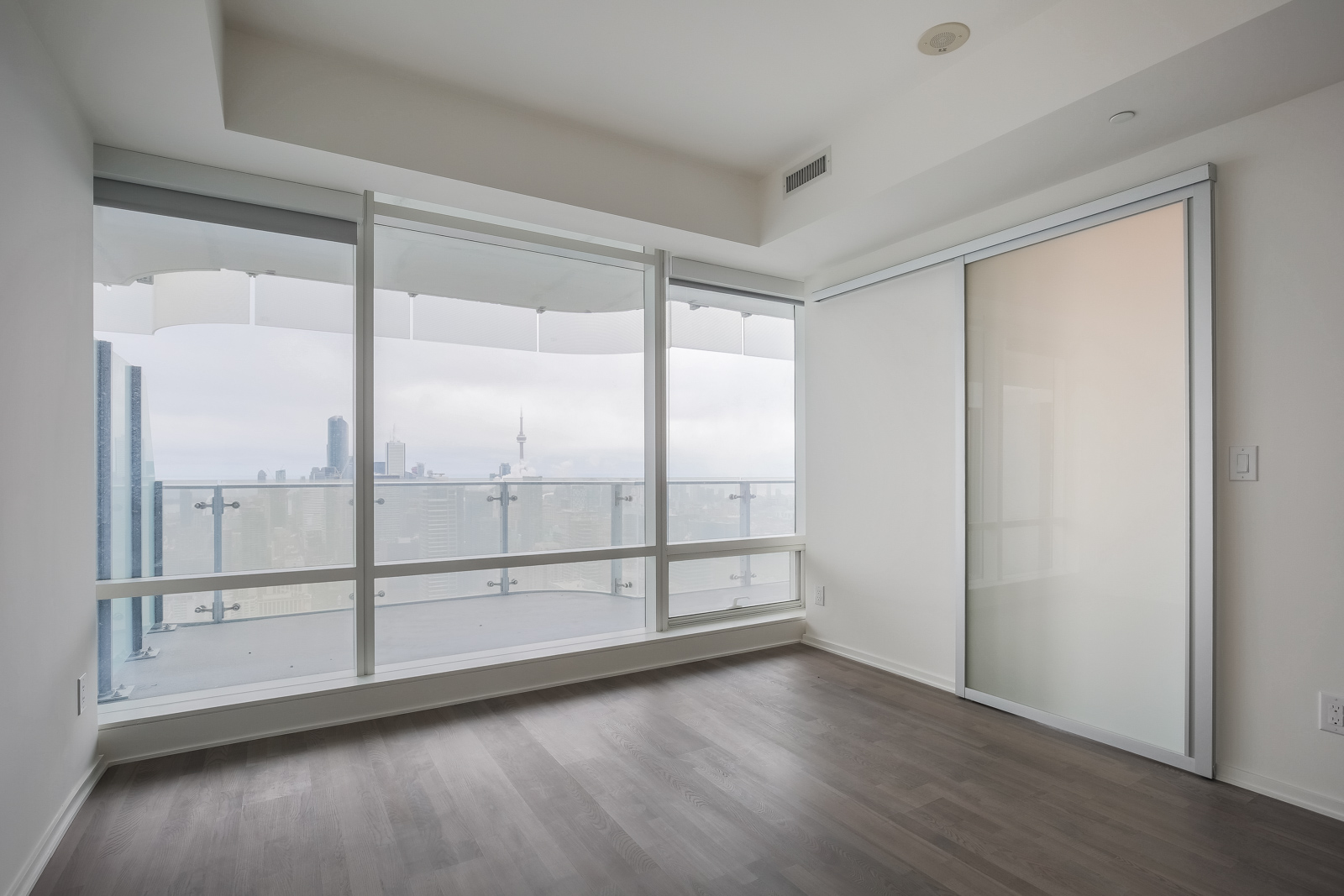 Picture showing large glass windows and view of Toronto from bedroom