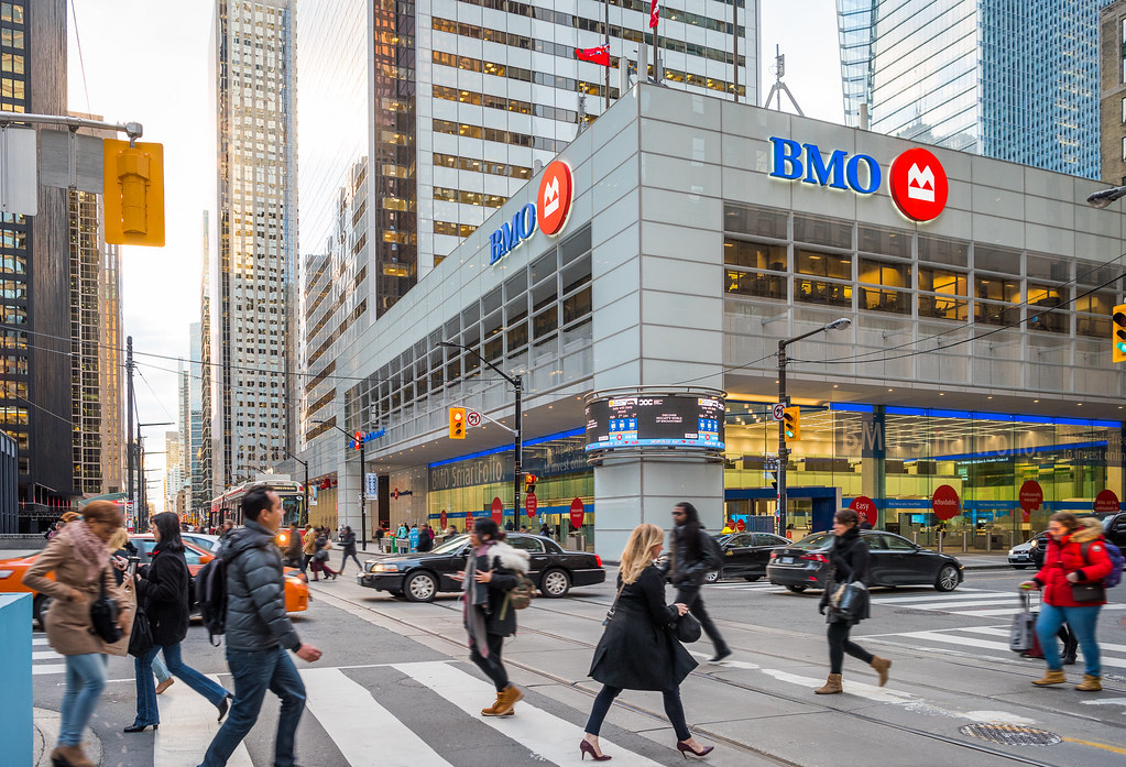 Pedestrians crossing street in foreground; BMO building in background.