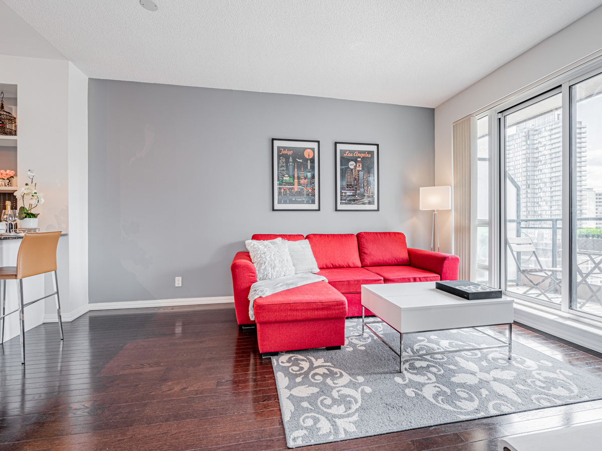 Condo living room with red sofa and empty space.