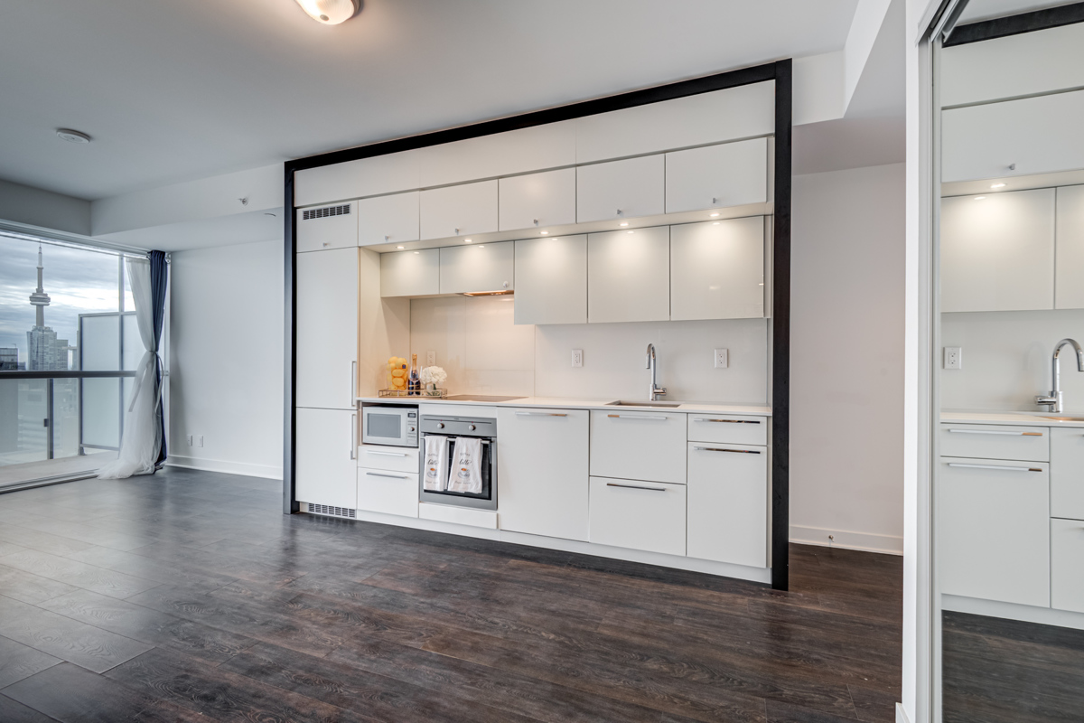 Linear kitchen with shiny white cabinets.