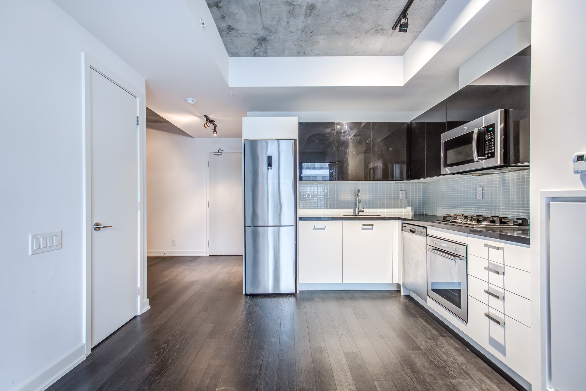 L-shaped kitchen with modern appliances at 39 Brant St Unit 918, Brant Park Lofts, in Queen West.