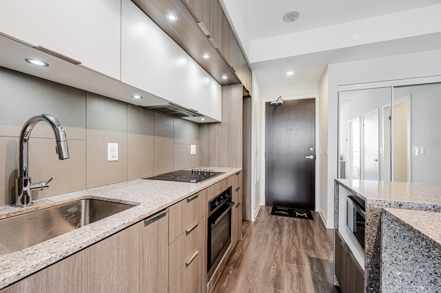 Condo kitchen with multiple wall-mounted and floor level cabinets and drawers.