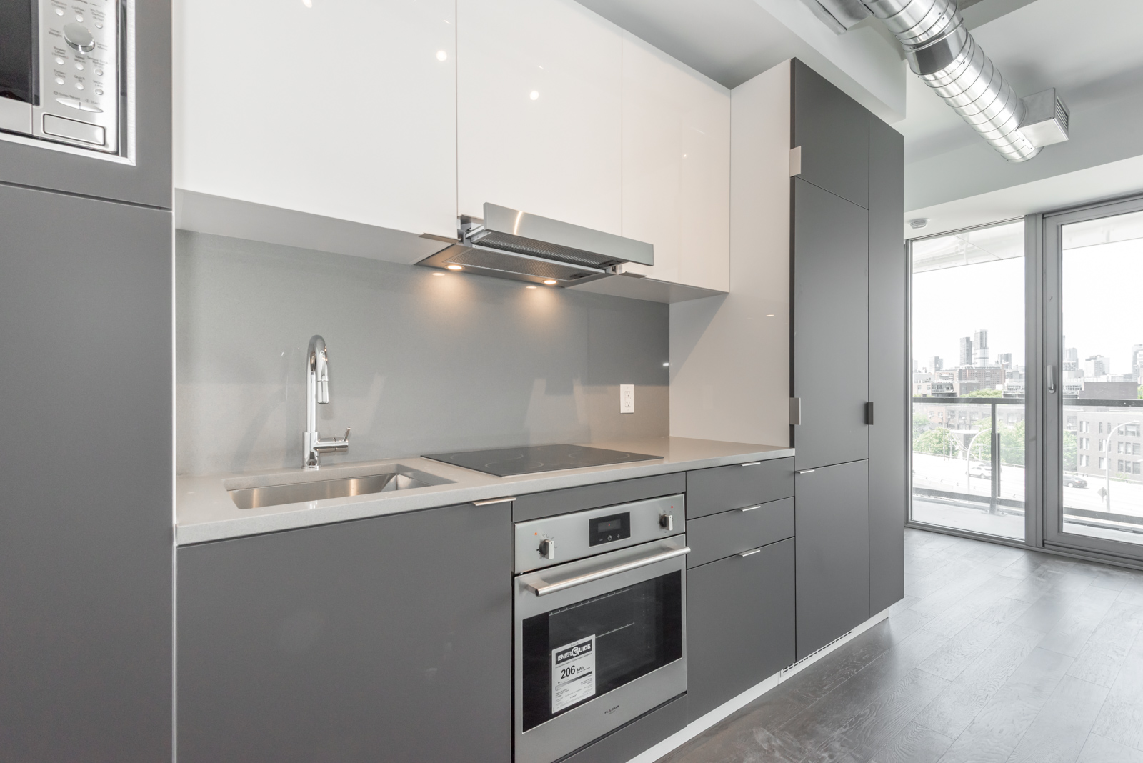 Lovely picture of kitchen and its cabinets, drawers, appliances and faucet.