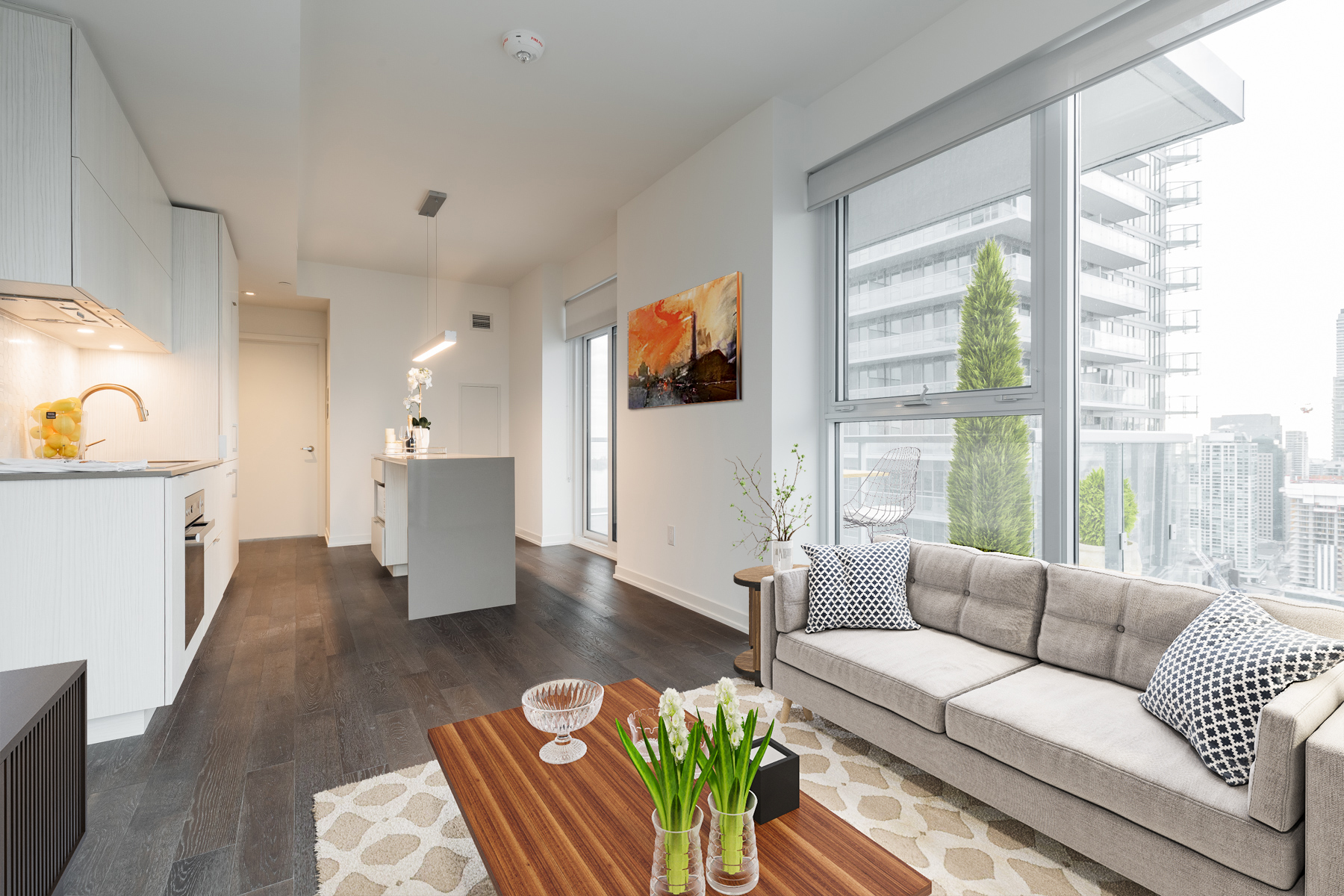 Living room with large windows and virtually staged furniture.