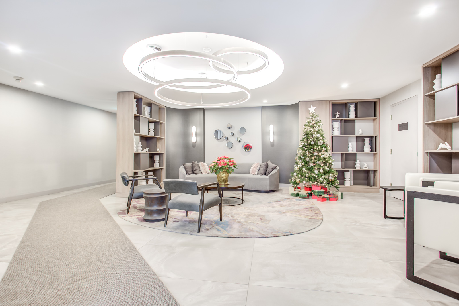 Twenty Collier lobby with Christmas tree, red flowers in vase and shelves full of ornaments.