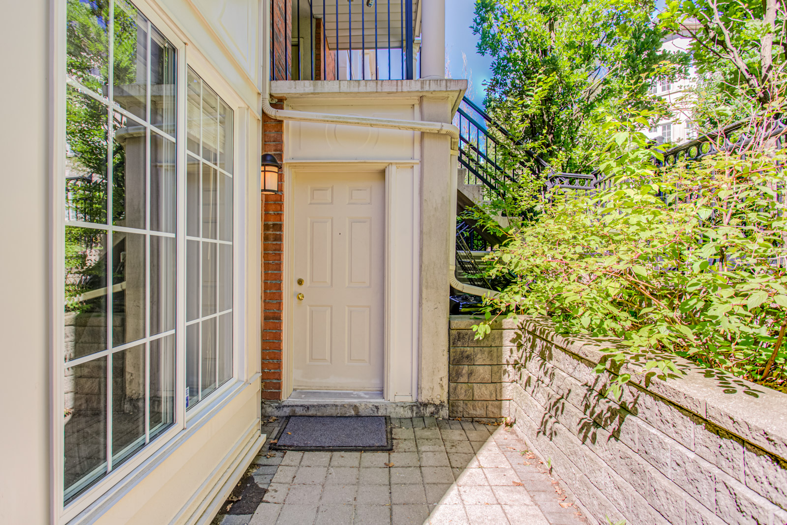 Front door of 5 Everson Dr with windows to left and greenery to right.